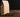 Brown paper bag beside coffee beans over a brown table